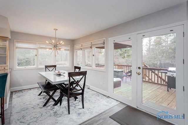 dining room with hardwood / wood-style floors and an inviting chandelier