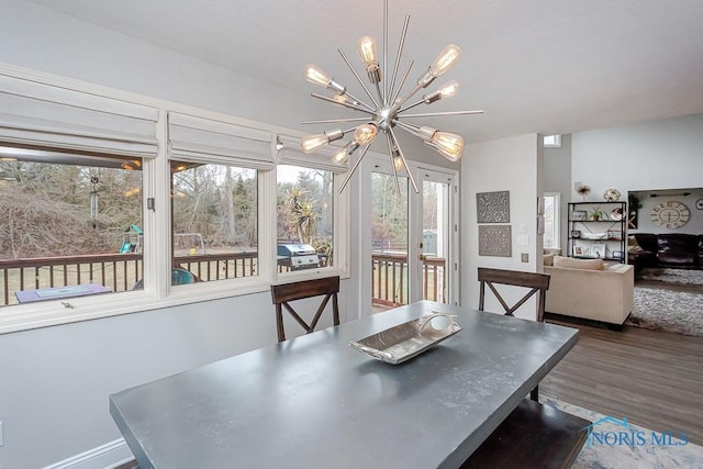 dining room featuring wood-type flooring and an inviting chandelier