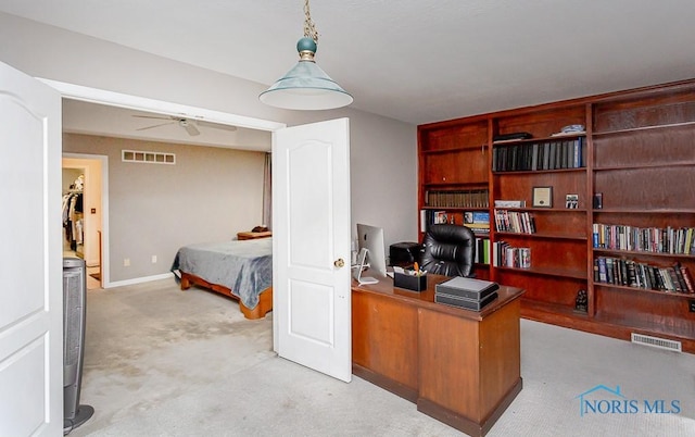 carpeted home office featuring ceiling fan