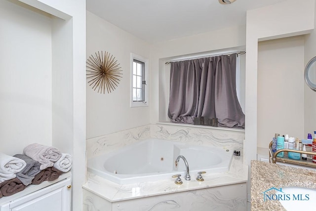 bathroom featuring a relaxing tiled tub and vanity