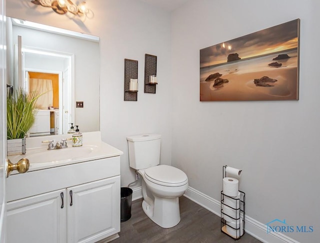 bathroom with vanity, wood-type flooring, and toilet