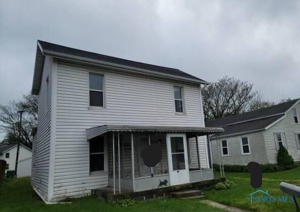 146 Railroad St, Tiffin, OH 44883 - back of house featuring a sunroom and a lawn