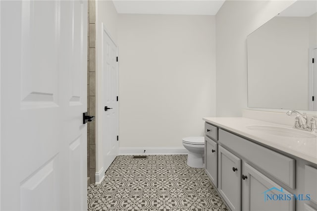 bathroom featuring tile patterned floors, vanity, and toilet