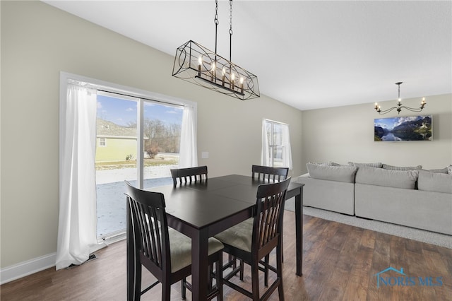 dining room with dark hardwood / wood-style flooring and a chandelier