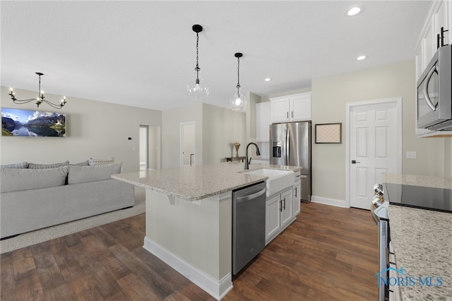 kitchen with pendant lighting, a kitchen island with sink, stainless steel appliances, white cabinets, and dark hardwood / wood-style flooring