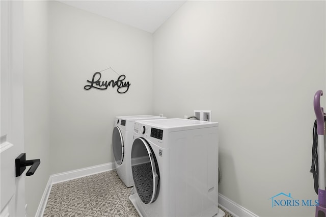 clothes washing area featuring light tile patterned floors and washer and dryer