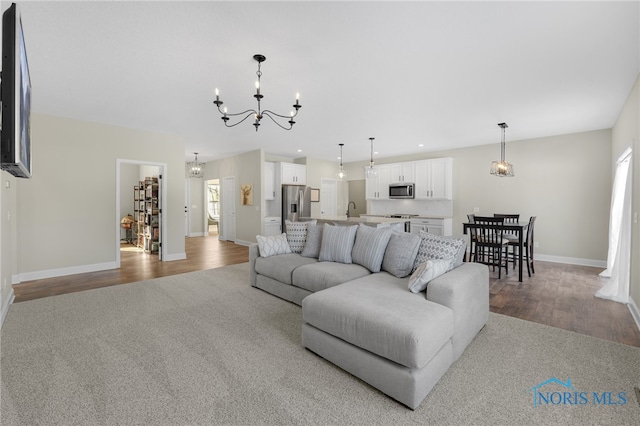 living room with light wood-type flooring and an inviting chandelier