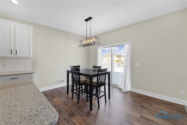 dining space with a chandelier and dark hardwood / wood-style flooring