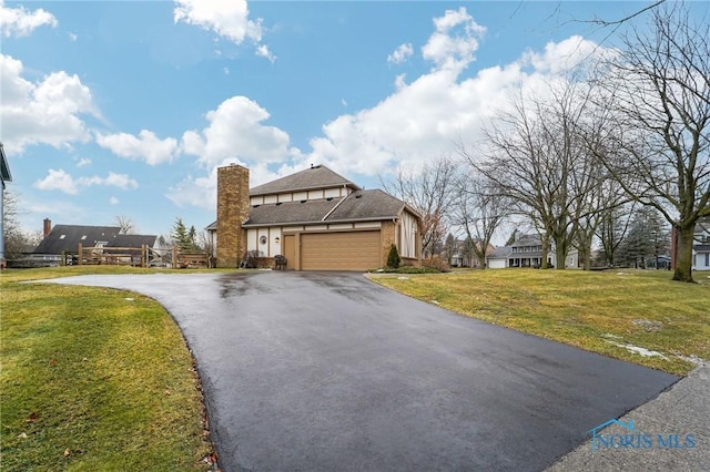 view of front of home with a garage and a front lawn