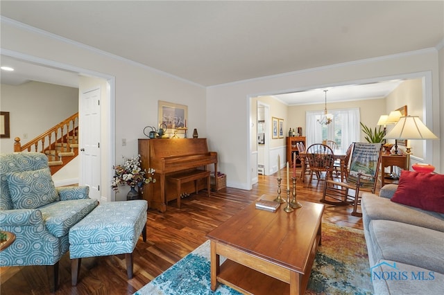 living room with crown molding, dark hardwood / wood-style floors, and a notable chandelier