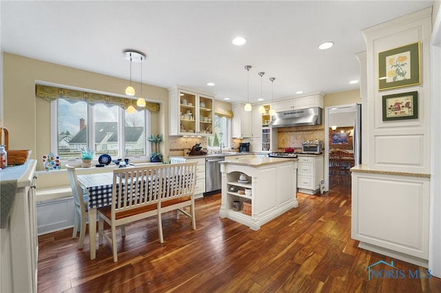 kitchen featuring a center island, stainless steel dishwasher, white cabinets, and decorative light fixtures