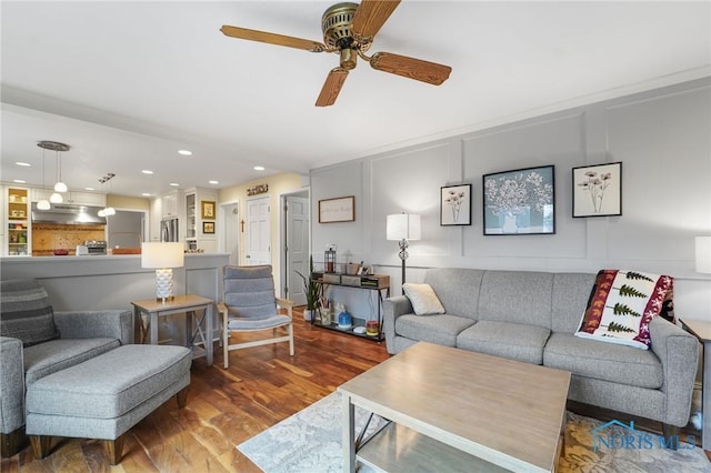 living room with wood-type flooring and ceiling fan