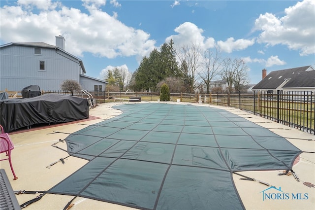 view of pool with grilling area and a patio area