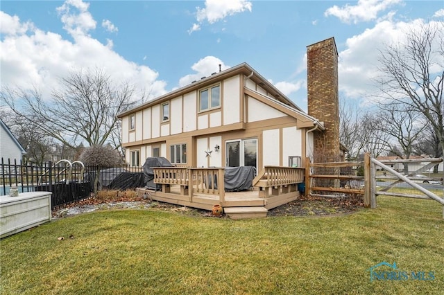 rear view of property with a yard and a deck