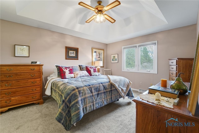 bedroom featuring a raised ceiling, carpet flooring, and ceiling fan