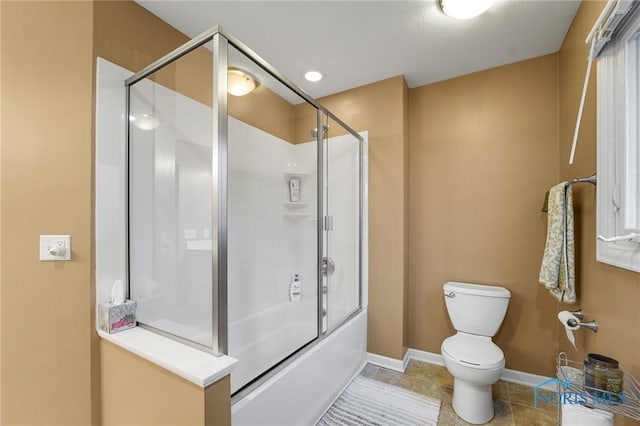 bathroom featuring tile patterned flooring, combined bath / shower with glass door, and toilet