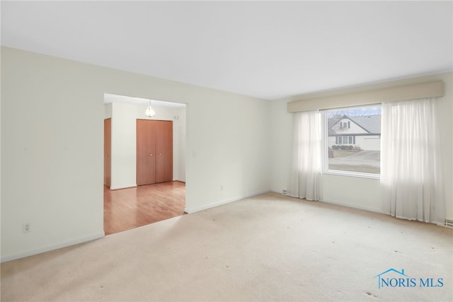 unfurnished room featuring carpet flooring and baseboards