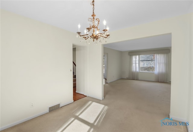 carpeted empty room featuring stairway, visible vents, and baseboards