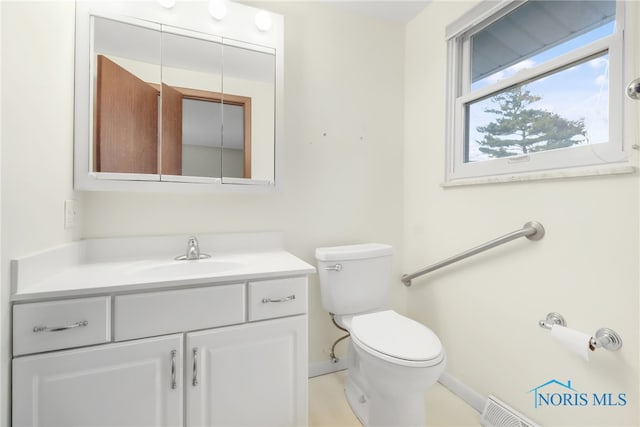 bathroom featuring toilet, baseboards, and vanity