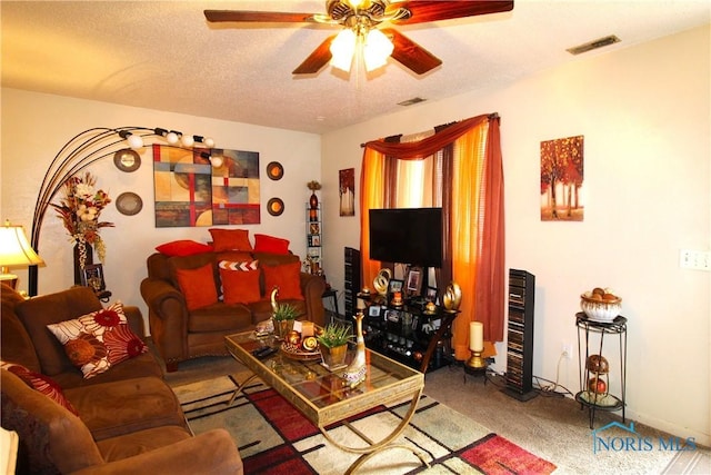 living room with ceiling fan, carpet, and a textured ceiling