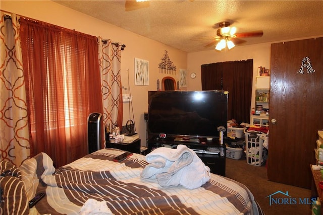 carpeted bedroom featuring ceiling fan and a textured ceiling