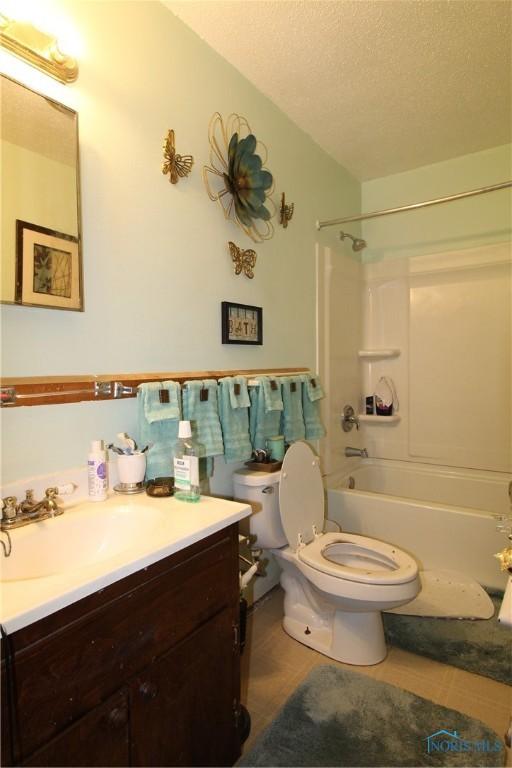 full bathroom featuring vanity, toilet, shower / bathing tub combination, and a textured ceiling