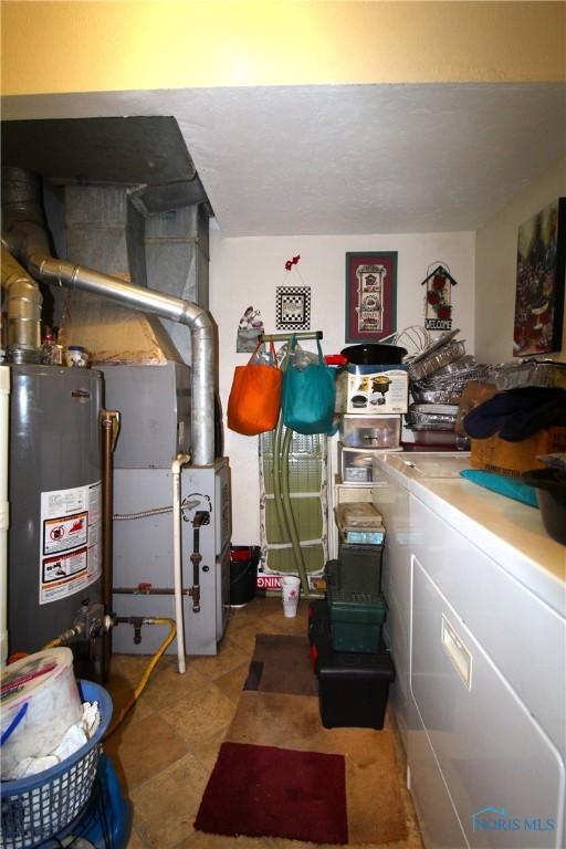 utility room featuring water heater and washer / dryer