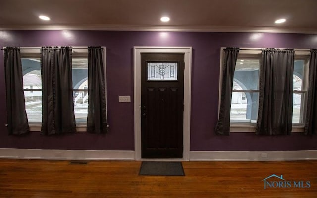 foyer with ornamental molding, dark hardwood / wood-style floors, and a wealth of natural light