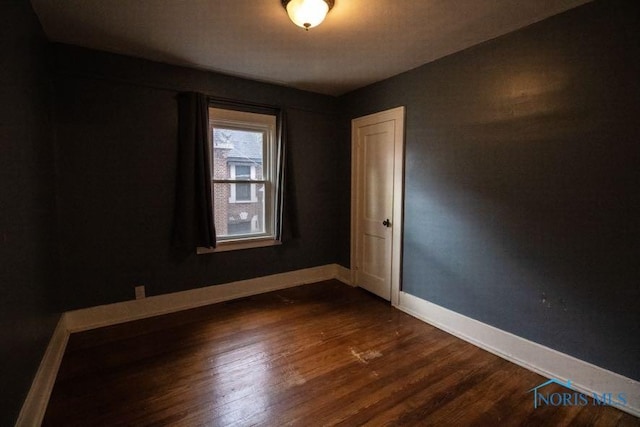 unfurnished room featuring dark wood-type flooring