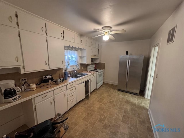 kitchen with white electric range oven, white cabinets, visible vents, and freestanding refrigerator