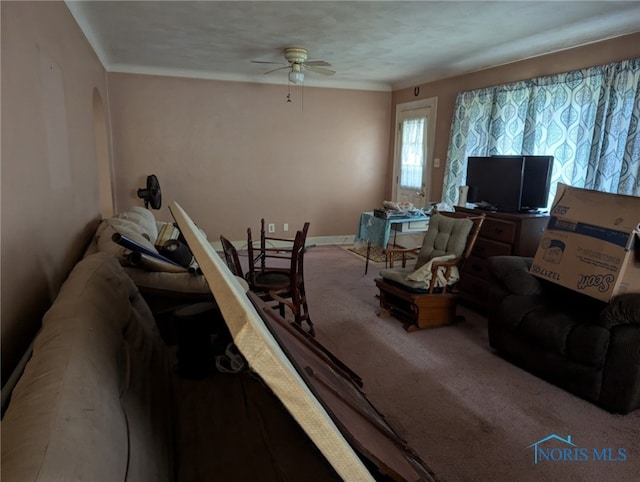 carpeted living area featuring baseboards and ceiling fan