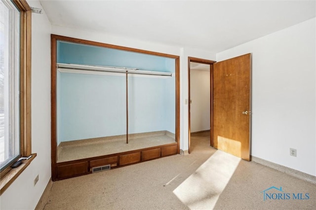 unfurnished bedroom featuring light colored carpet and a closet