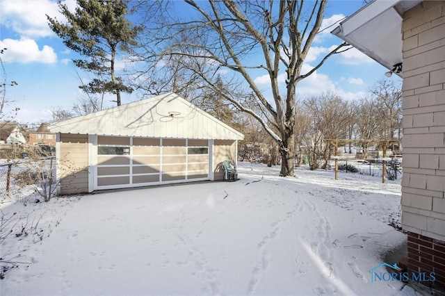 yard covered in snow featuring a garage and an outdoor structure