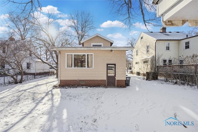 view of snow covered back of property