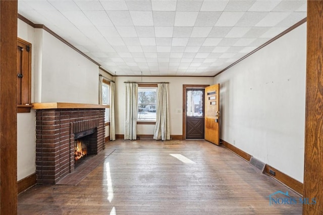 unfurnished living room with hardwood / wood-style flooring, a fireplace, and ornamental molding