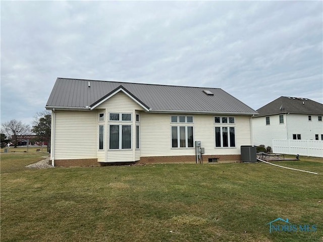 back of house featuring a yard and central air condition unit