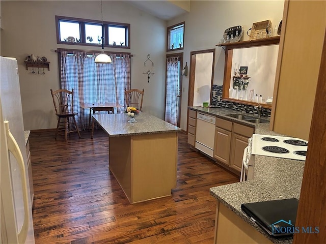 kitchen featuring sink, white appliances, a center island, light stone counters, and dark hardwood / wood-style flooring