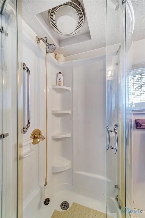 bathroom featuring walk in shower and a textured ceiling