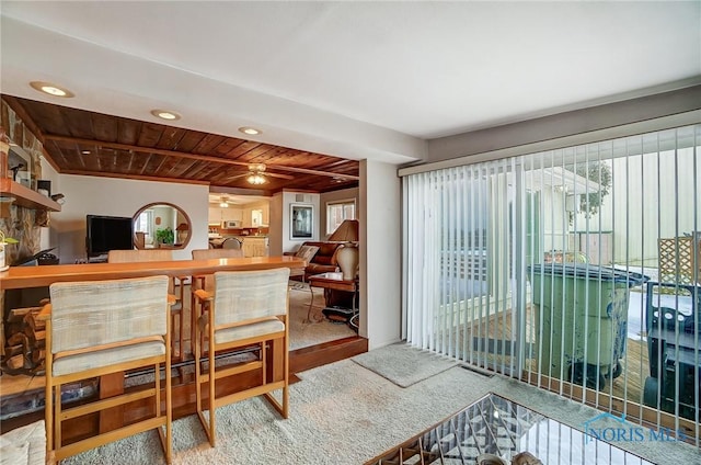 carpeted dining room with ceiling fan and wood ceiling