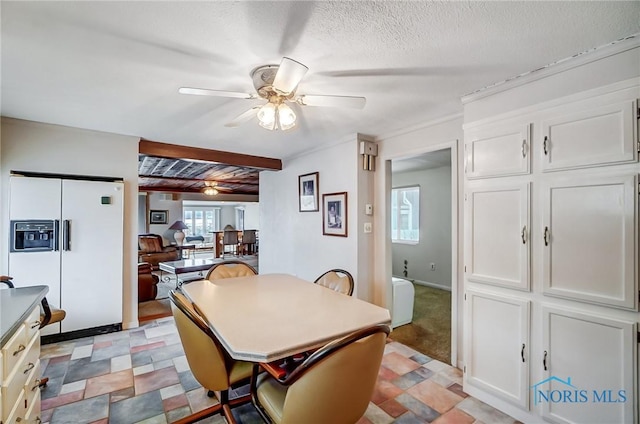 dining area with beam ceiling, a textured ceiling, and ceiling fan