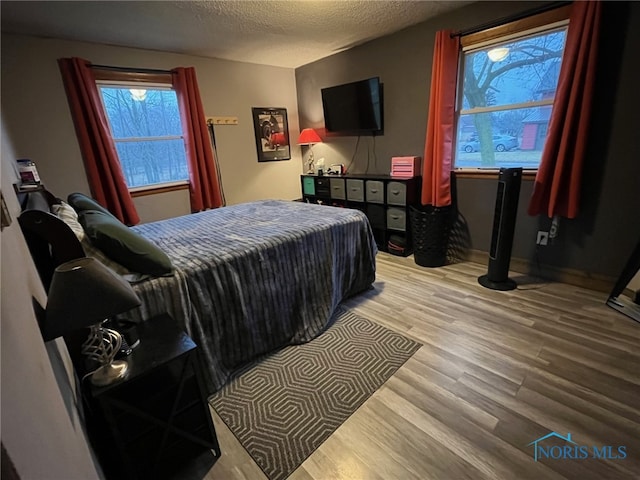 bedroom featuring a textured ceiling and light hardwood / wood-style floors