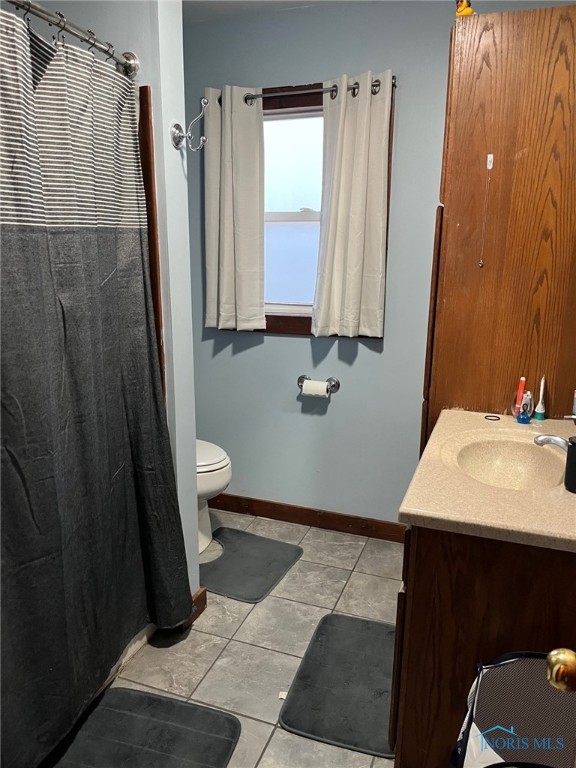 bathroom featuring vanity, tile patterned floors, and toilet