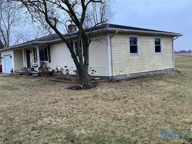 view of property exterior featuring a garage and a lawn