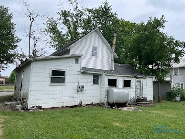 rear view of property featuring a lawn