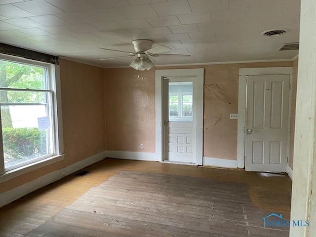 spare room with crown molding, wood-type flooring, and ceiling fan