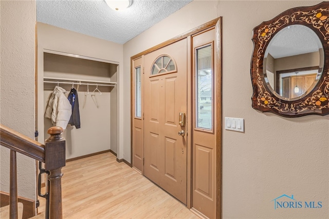 entrance foyer featuring a textured ceiling and light hardwood / wood-style floors