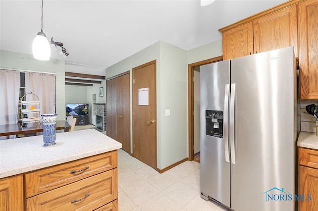 kitchen with pendant lighting, light tile patterned floors, and stainless steel fridge