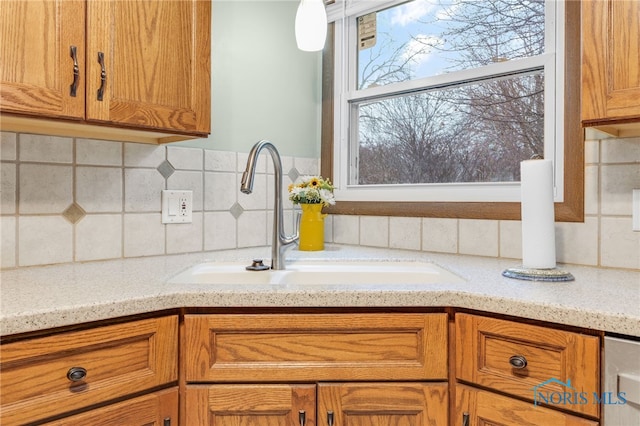 kitchen with sink, backsplash, and light stone countertops