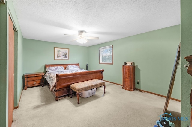 carpeted bedroom with ceiling fan and a textured ceiling