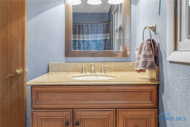 bathroom featuring a shower with curtain and vanity